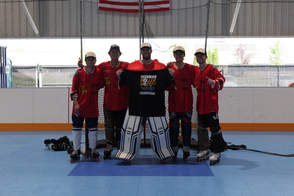 A roller hockey team in red jerseys poses at the Flexible Arena during the Roll For Gold weekend.